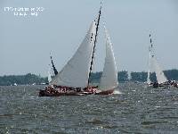De 'Twa Famkes' zeilt nu goed aan de wind. Eelke Boersma, met de 'Hoop op Zegen' is al door de wind en worstelt met een harde vlaag.